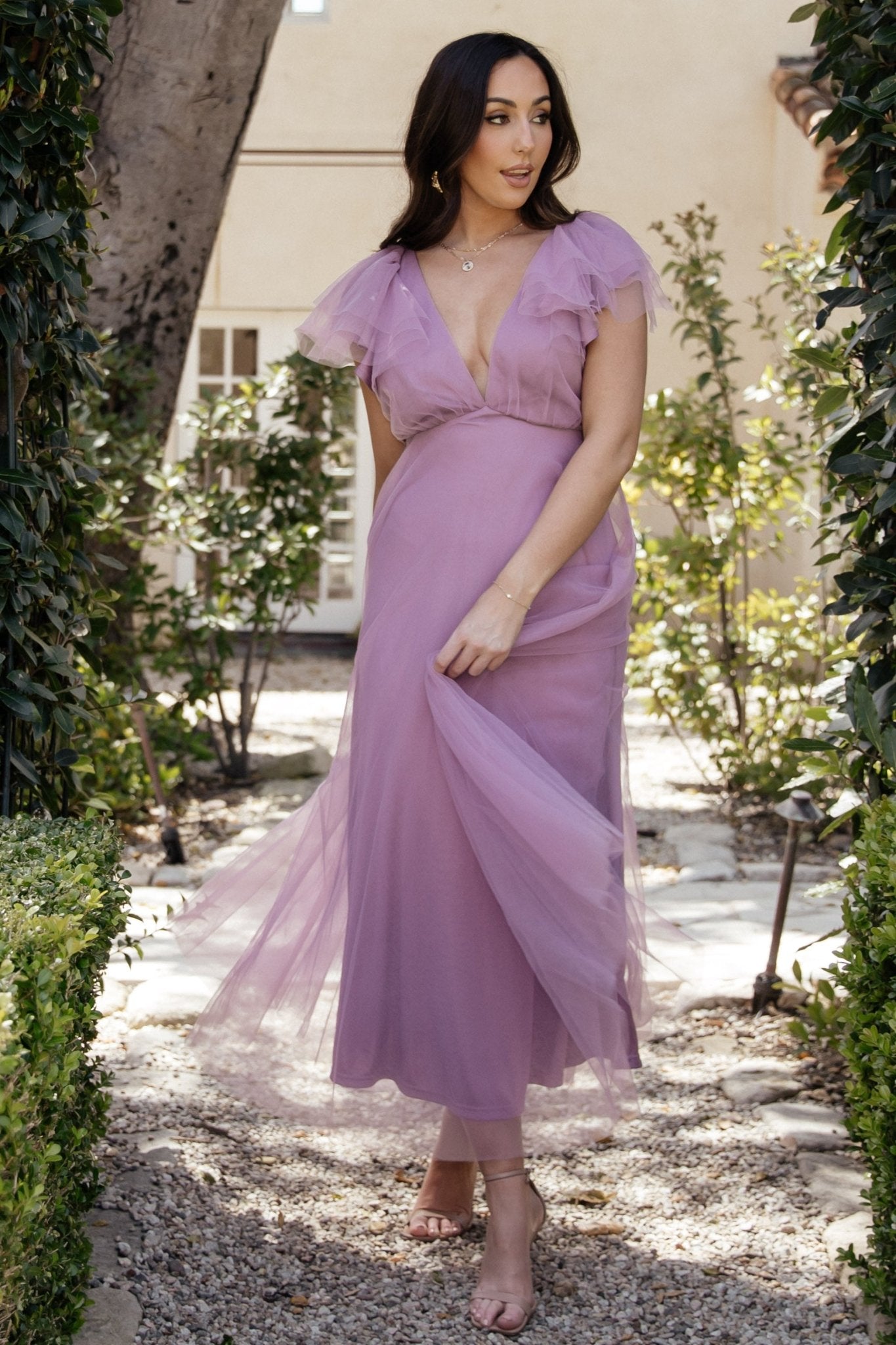Model walking in Annabella Tulle Midi Dress lavender with airy movement from multiple tulle layers, ideal for weddings and semi-formal events.