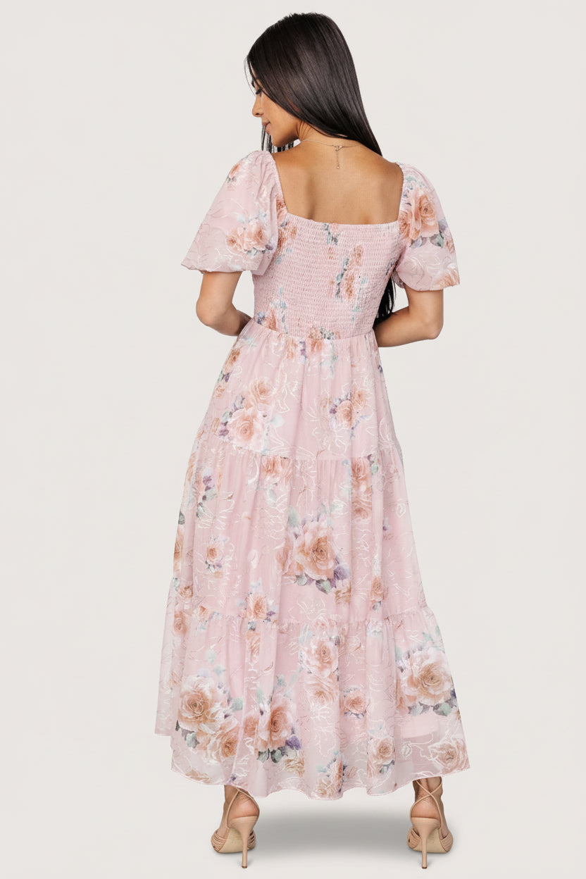 Close-up detail of gold and cream floral embroidery on blush tulle fabric, highlighting texture and stitchwork.