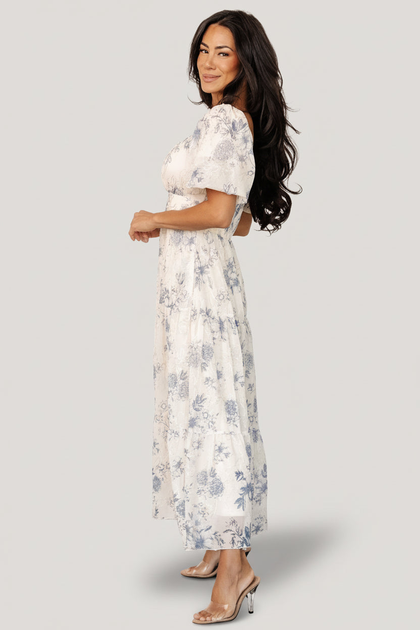 Back view showing smocked back bodice of cream and slate floral tulle dress, offering stretch and comfortable fit.