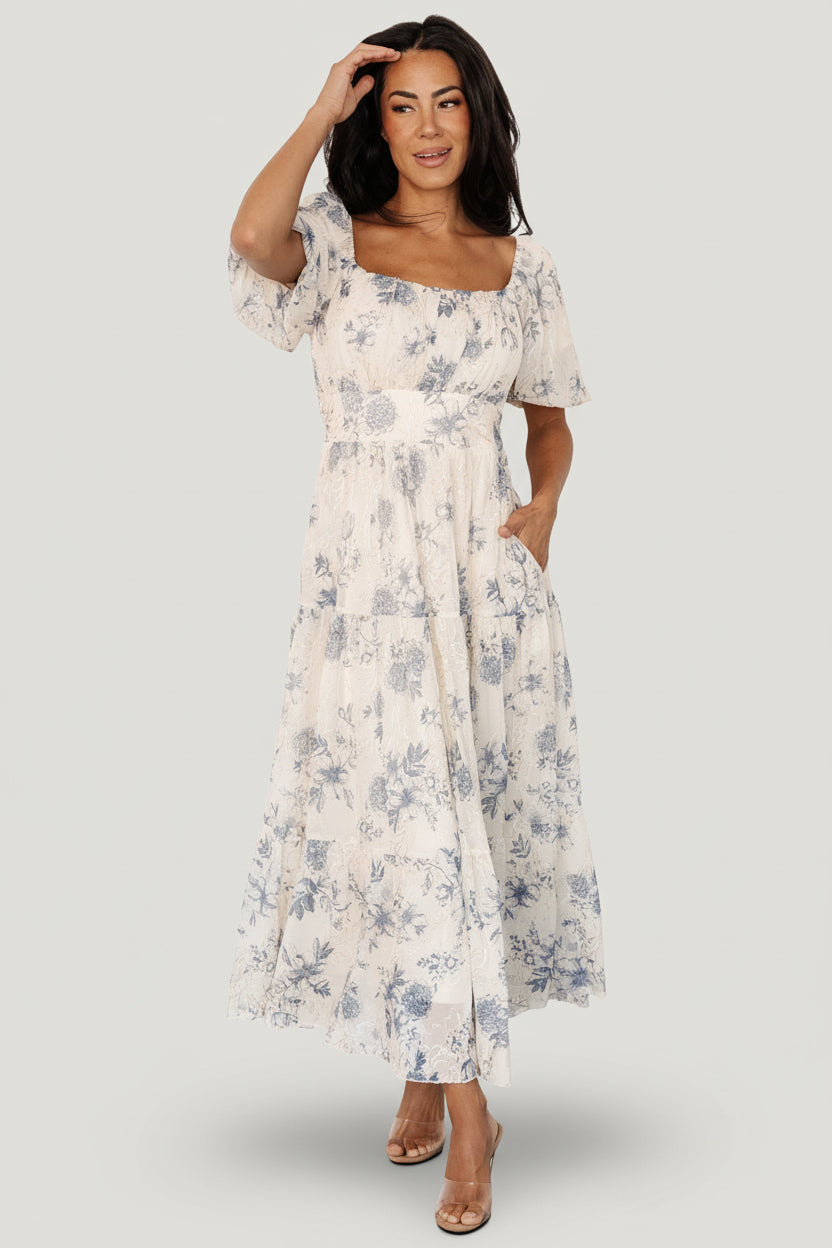 Cream and slate floral tulle midi dress with gold and cream embroidery, smocked back and three-tier skirt, hidden pockets.