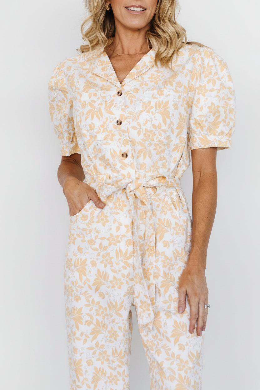 Close-up of Annalise jumpsuit fabric and yellow floral print showing shirt collar, button placket, and chest pocket details.