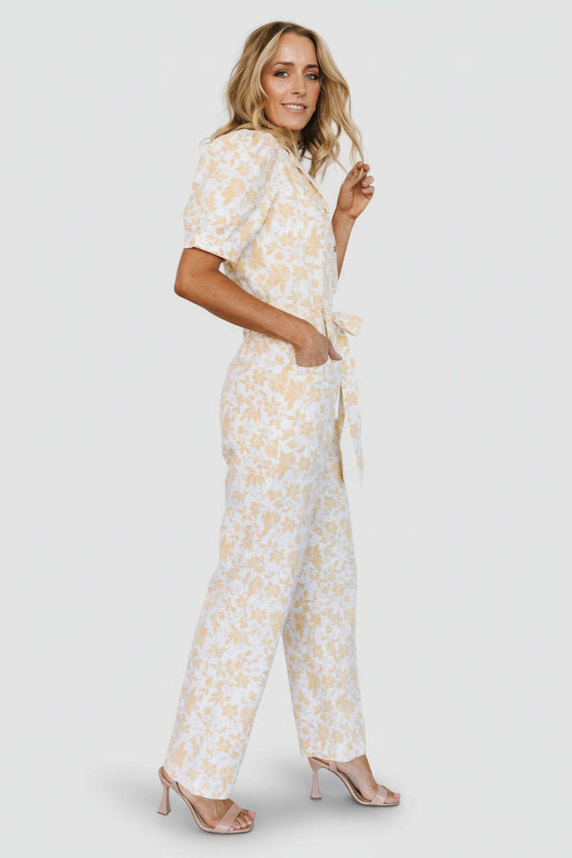Side view of Annalise jumpsuit highlighting puff short sleeves, self-tie sash at waist, and straight pant leg silhouette.