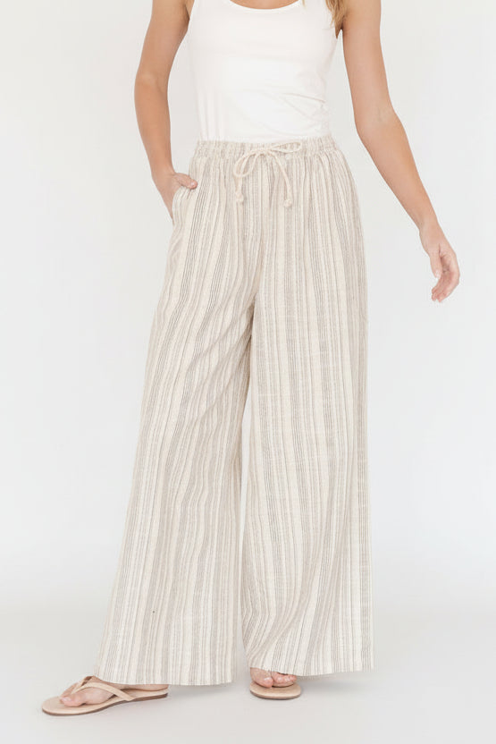 Front view of Antale wide-leg pants in natural brown multi-stripe linen showing elastic drawstring waist and relaxed silhouette.
