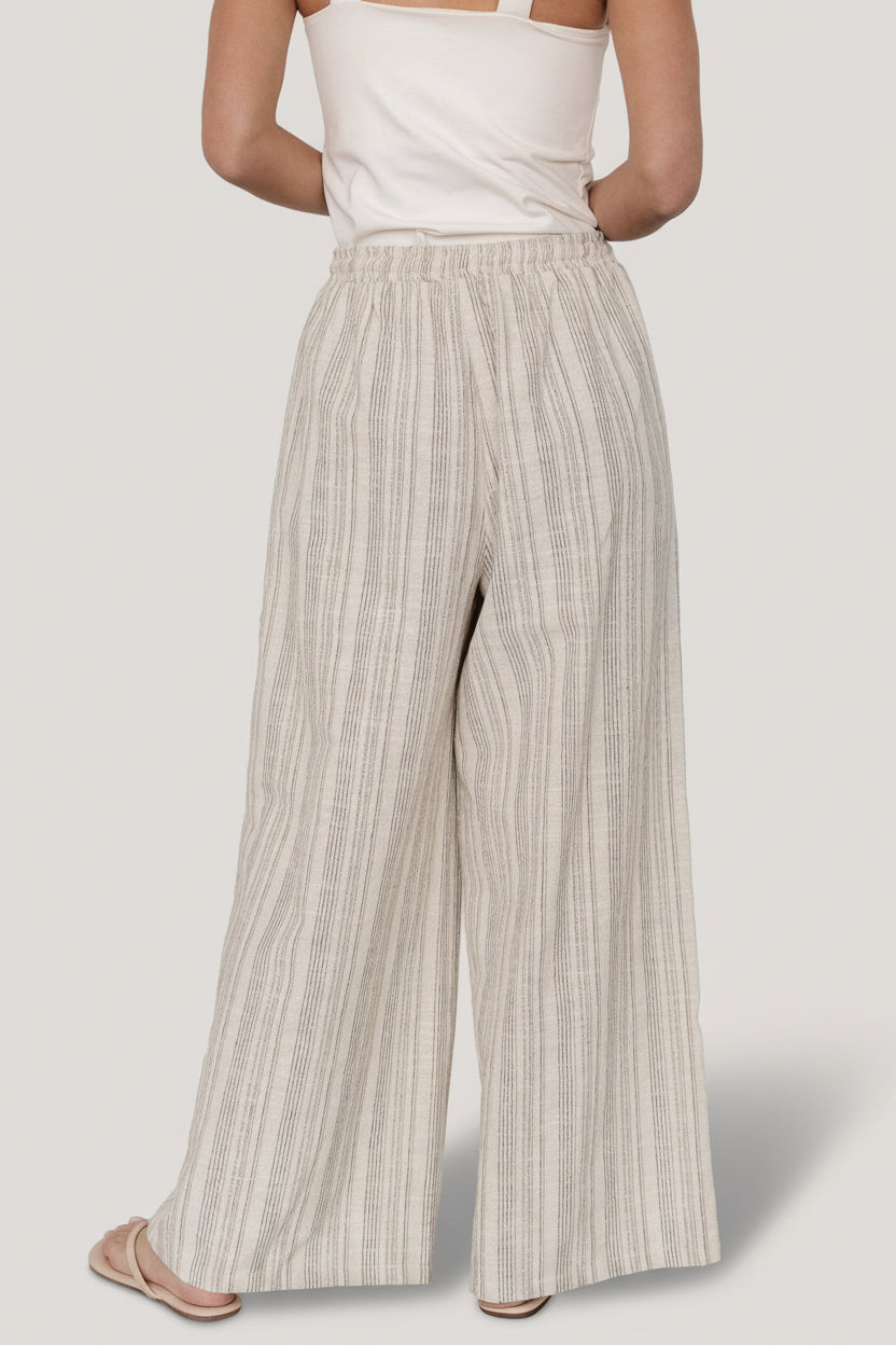 Close-up of Antale pants fabric in natural and brown stripes highlighting textured linen blend and stitch detail at seam.