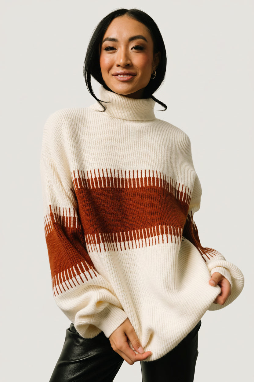 Front view of Antonov turtle-neck sweater in cream and spice colorblock on model, slightly oversized fit with long balloon sleeves and ribbed hem.