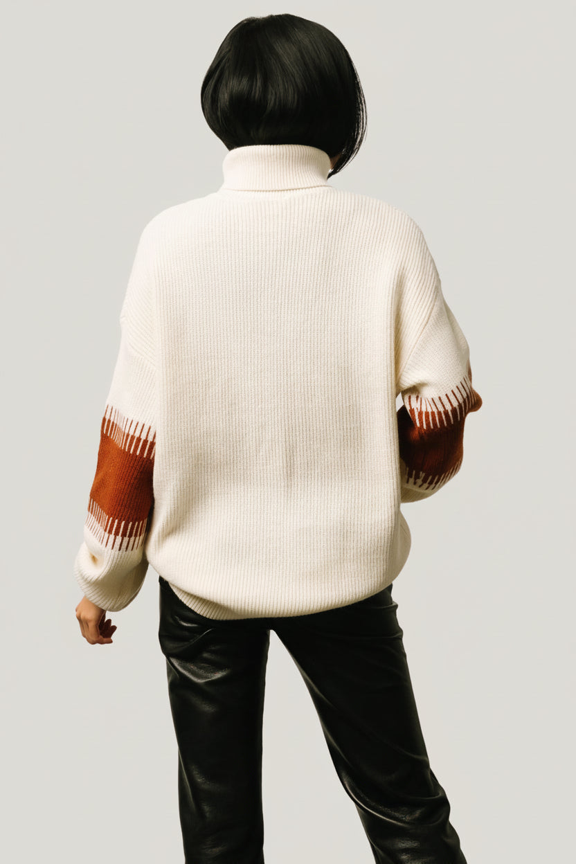 Flat-lay of the Antonov turtle-neck sweater in cream and spice, folded to display colorblock panels, ribbed hem, and soft knit fabric.