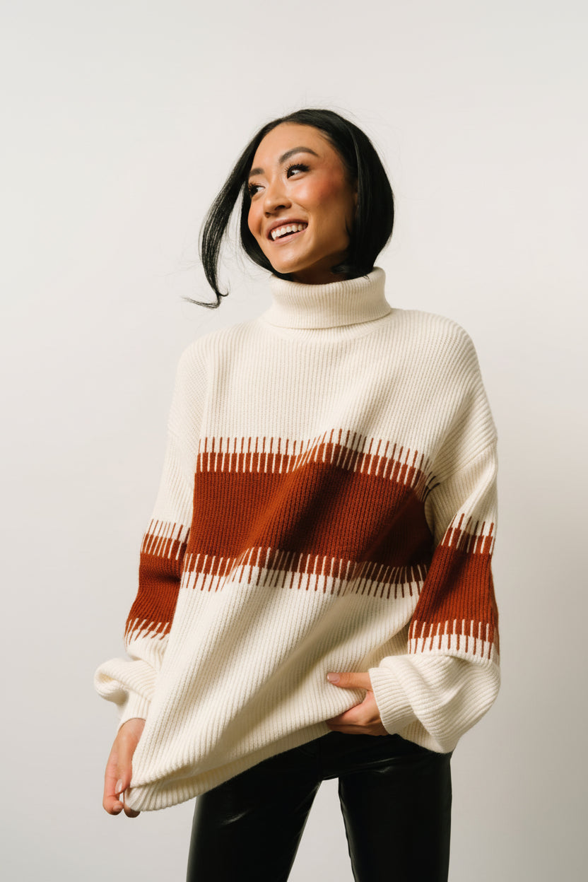 Detail view of long balloon sleeve and cuff on cream and spice Antonov sweater, illustrating knit stitch, volume, and ribbed cuff construction.