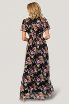 Back view of Ardley Maxi Dress in black multi floral showing skirt drape, length and embroidered textured detail across the fabric.
