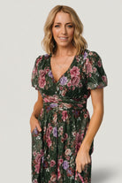 Close-up of Ardley dress bodice showing V-neckline, soft mesh overlay, and delicate embroidered green floral detail.