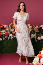 Close-up of waist gathering and seam detail on cream floral maxi dress, illustrating fit at the natural waist.
