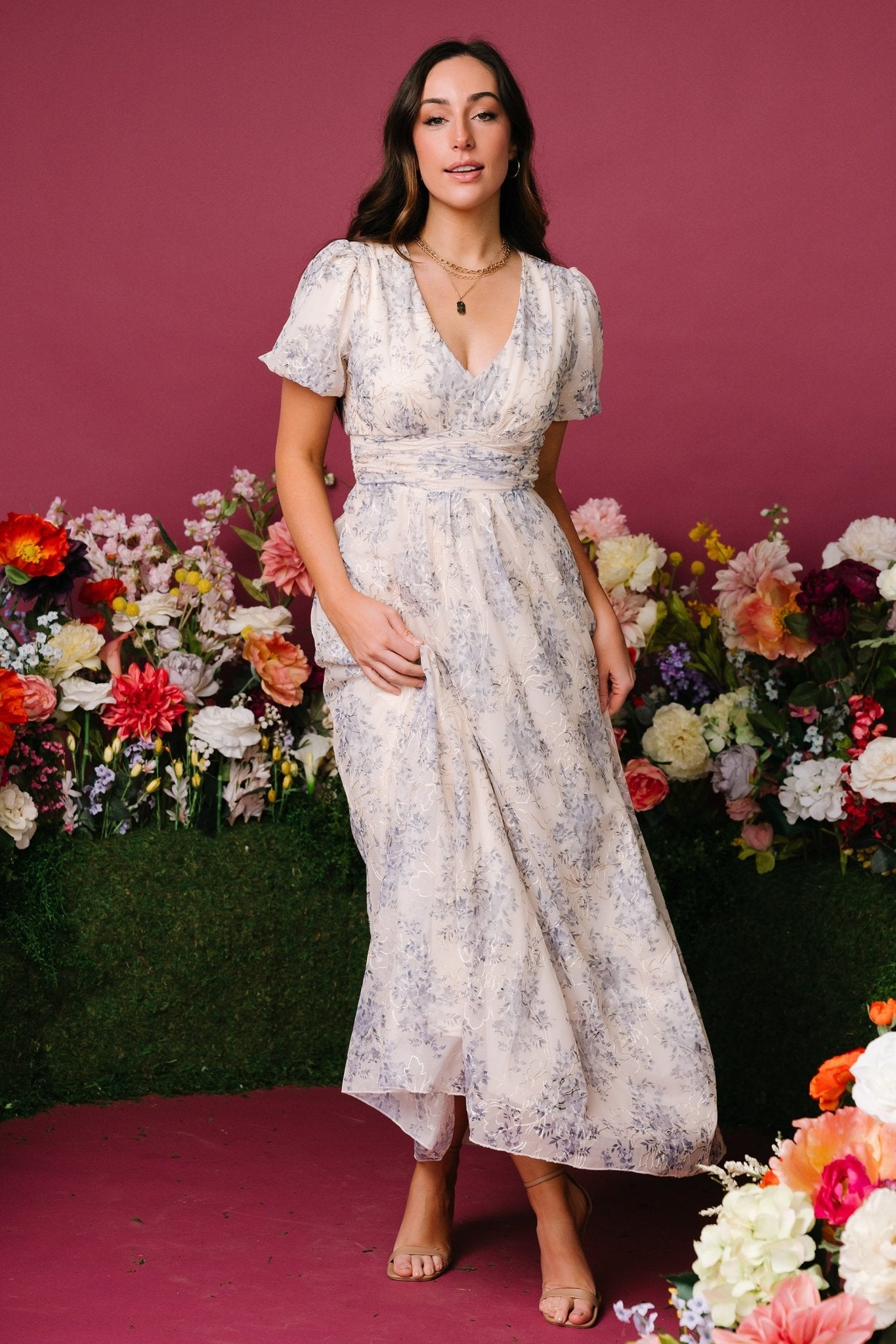 Close-up of waist gathering and seam detail on cream floral maxi dress, illustrating fit at the natural waist.