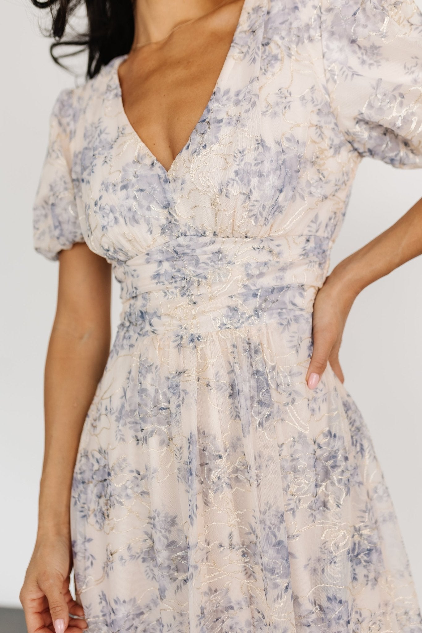 Back and movement view of the cream and blue maxi dress, showing full skirt length and natural drape of the mesh overlay.