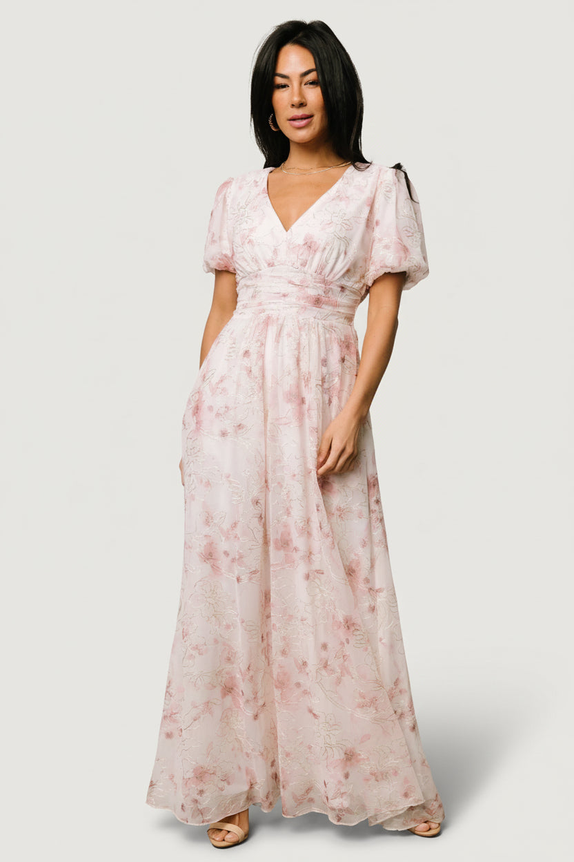 Front view of Ardley Maxi Dress in mauve floral with gold and cream embroidery, V-neck, short puff sleeves, gathered waist, and side pockets (model view).