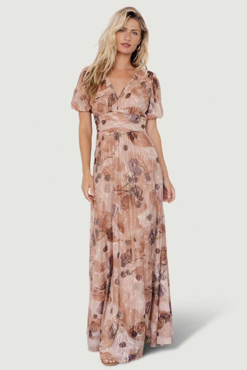 Front view of Ardley taupe floral maxi dress on model showing V-neck, short puff sleeves, gathered waist and flowing skirt with embroidered detail.