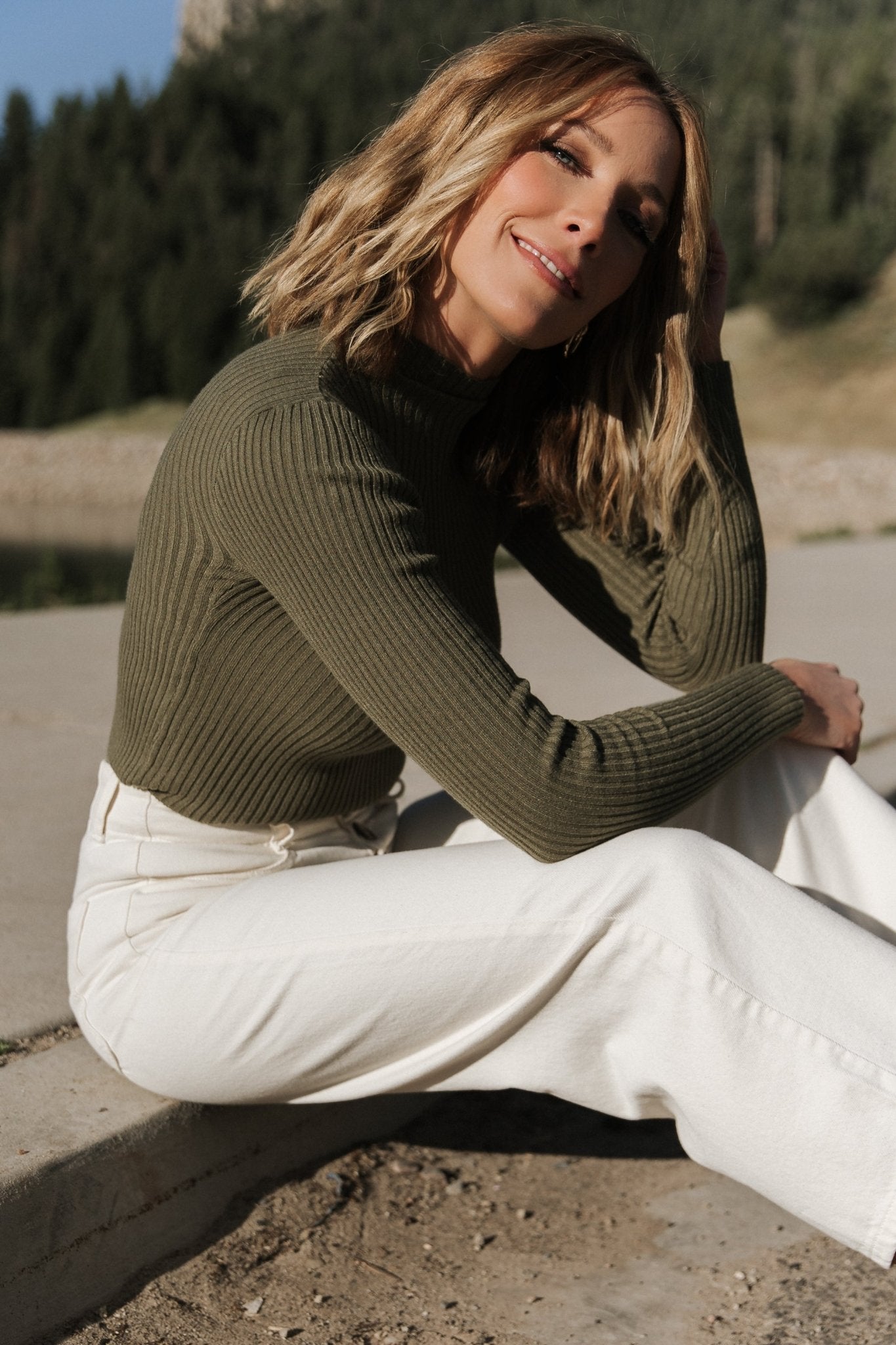 Side view of fitted olive ribbed top showing bodycon fit and long sleeve length.