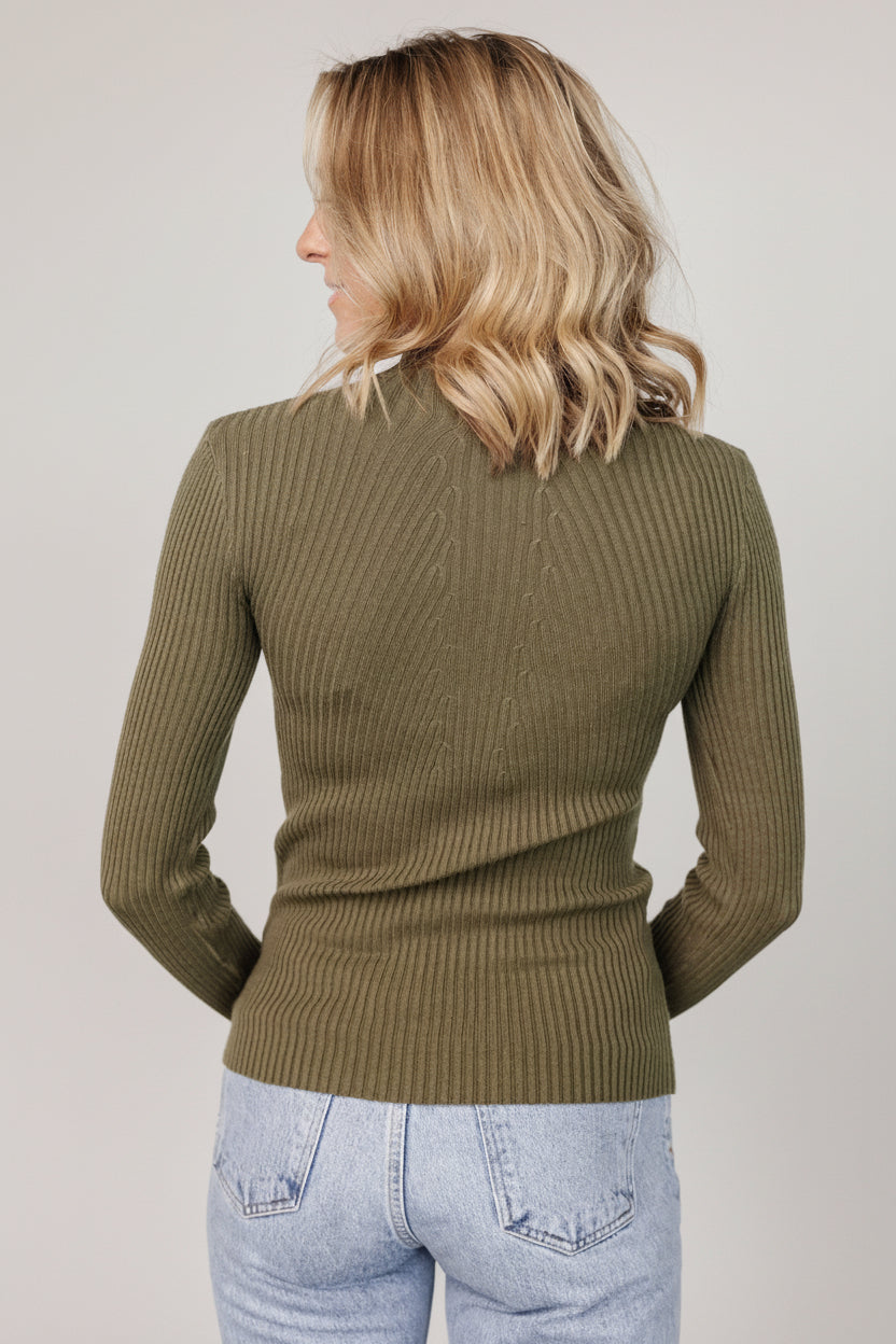 Model wearing olive Ari top tucked into high-waist bottoms to show silhouette and styling option.