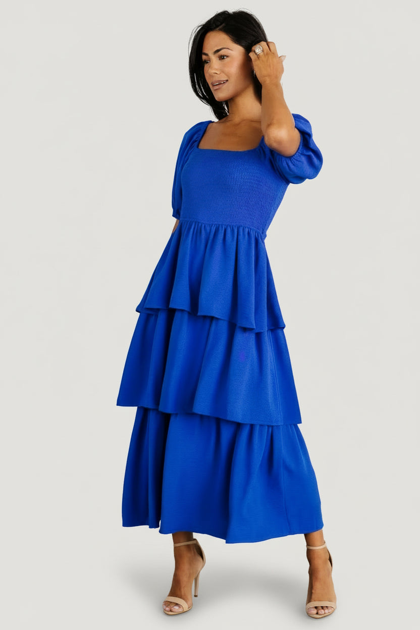 Styled look of the cobalt tiered dress on model, showing midi length, square neckline, and how the tiers move while walking.