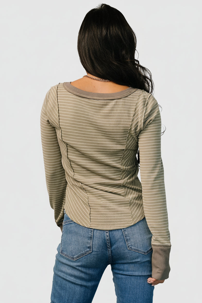 Rear view of olive striped top displaying back seaming, stripe alignment, and overall relaxed silhouette on model.