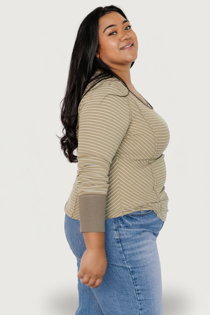 Model wearing olive striped long-sleeve top styled with casual bottoms to show everyday outfit possibilities.