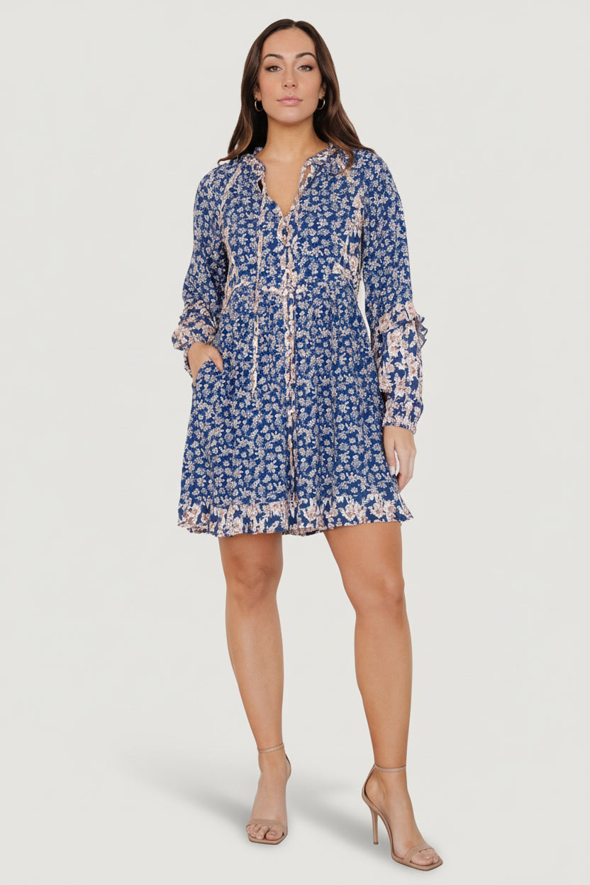 Front view of navy multi floral short dress with notched ruffle V-neck, working front buttons, and ruffled hem.