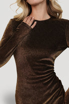 Close-up of the bronze metallic material and bodice detailing, highlighting fabric texture, stitching and tailored darts at the bust.