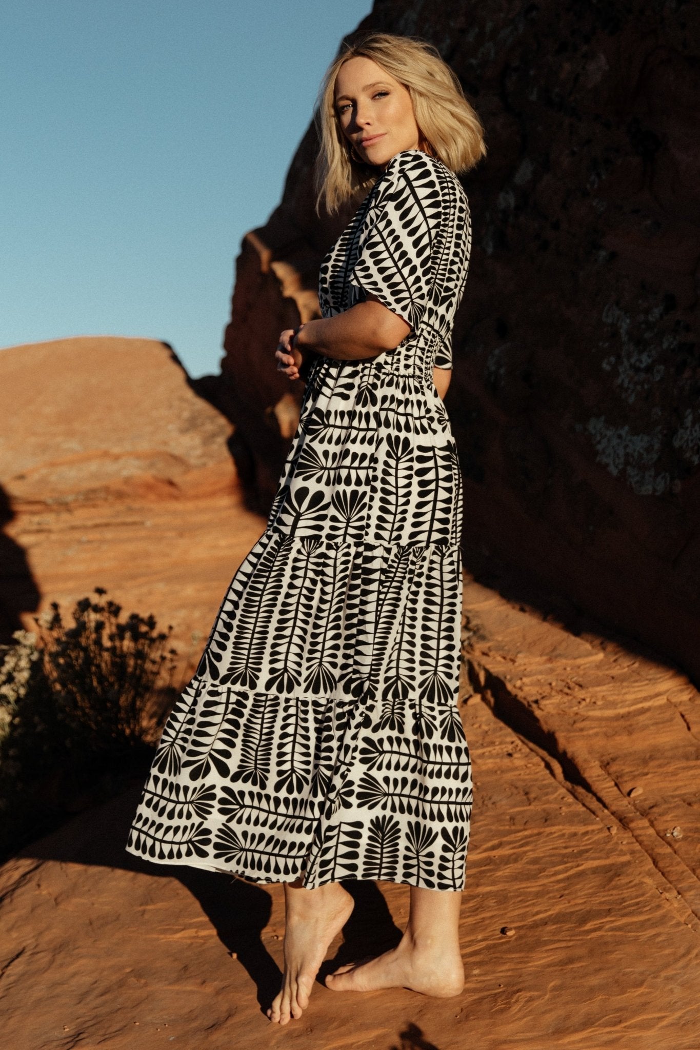 Detail of sleeve and shoulder showing loose kimono sleeve shape and V-neck seam on the Austin Kimono Dress in black print.