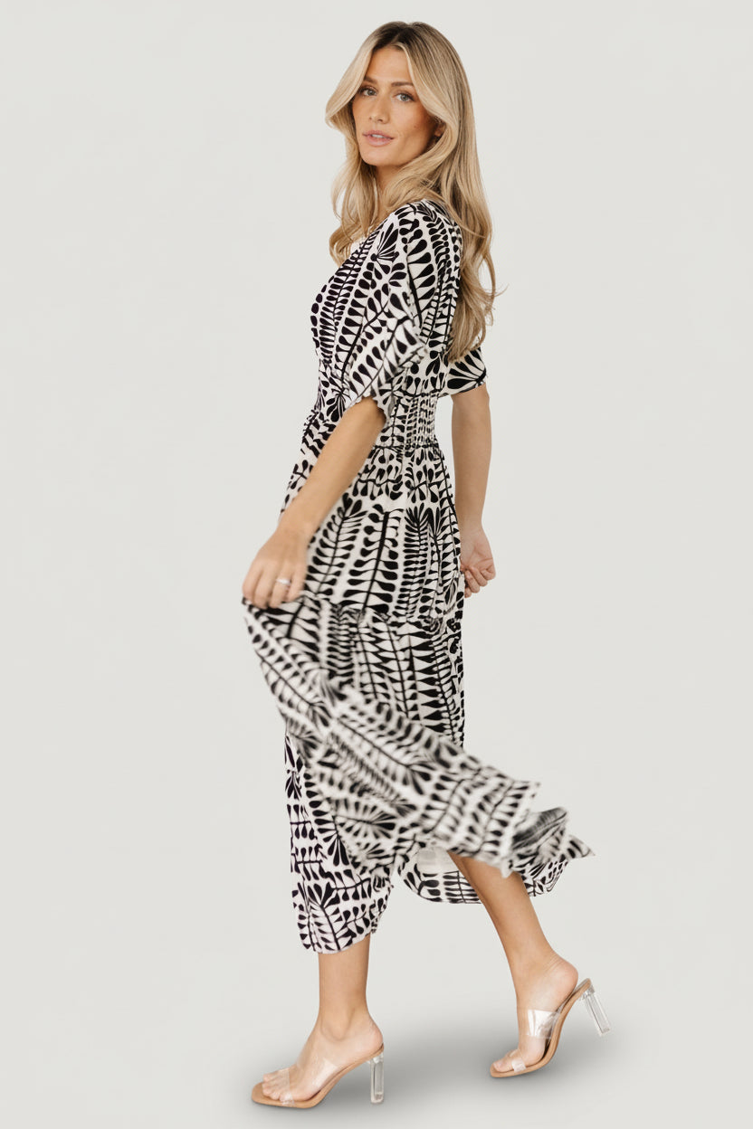 Studio flat-lay and styled shot of Austin Kimono Midi Dress showing fabric drape, lining, and V-neck detail in black print.