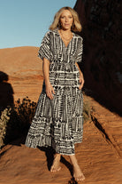 Close-up of fabric and print showing black motif on ivory background with lightweight polyester texture and fully lined construction.