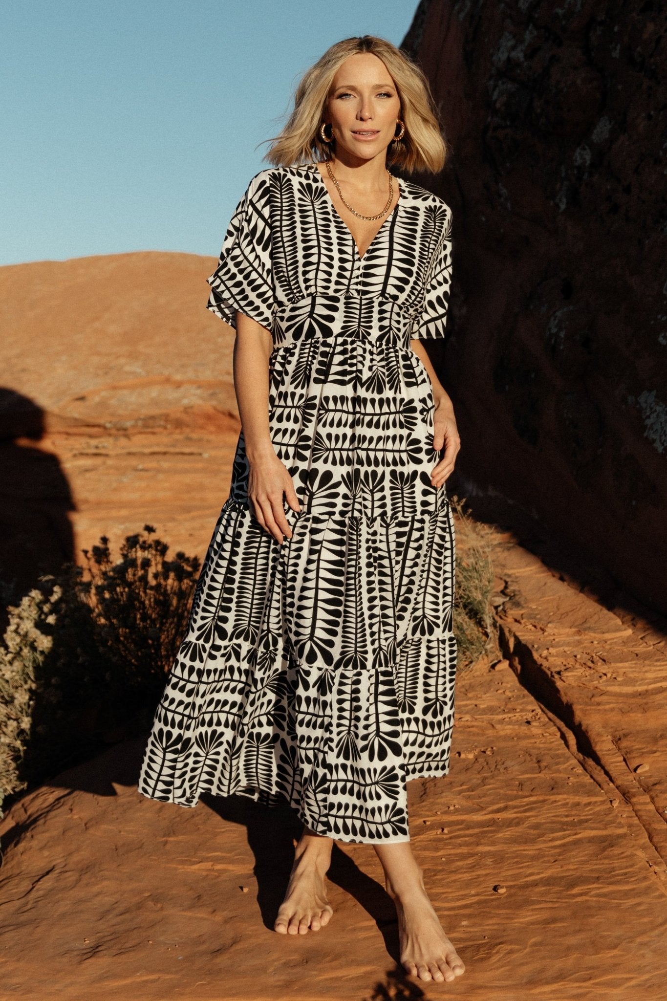 Close-up of fabric and print showing black motif on ivory background with lightweight polyester texture and fully lined construction.