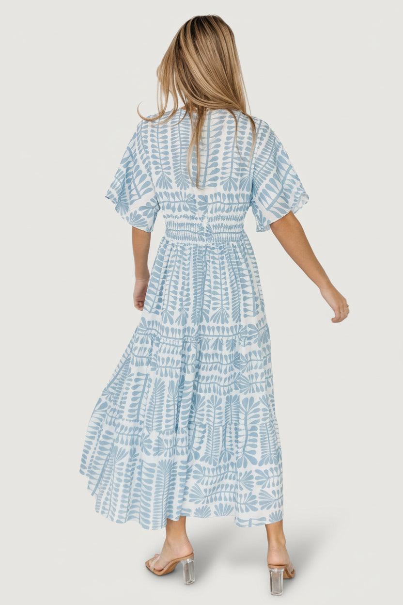 Model wearing blue-print midi kimono dress with gentle tiered skirt movement and classic V-neck styling for casual or event wear.
