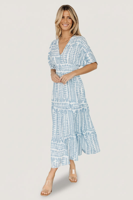 Front view of blue-print midi kimono dress showing V-neck, loose kimono sleeves, smocked back waistband and tiered skirt in soft blue tones.