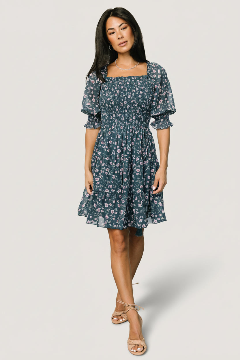Front view of Azlyn smocked short dress in blue multi floral jacquard chiffon, showing square ruffled neckline and smocked bodice for fit.