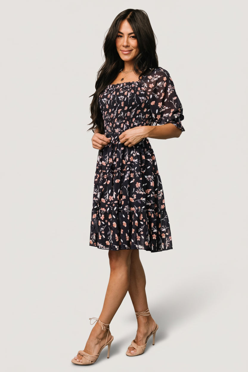 Close-up of smocked bodice and ruffled square neckline on Azlyn dress, highlighting elastic detailing and floral pattern.