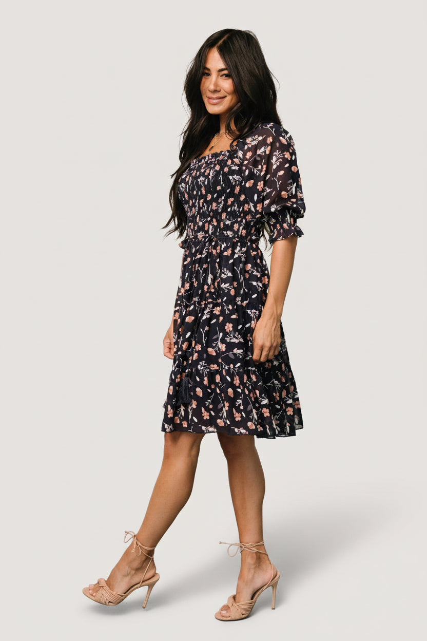 Close-up of tiered short skirt and flowing chiffon fabric on Azlyn dress, showing movement and delicate floral print.
