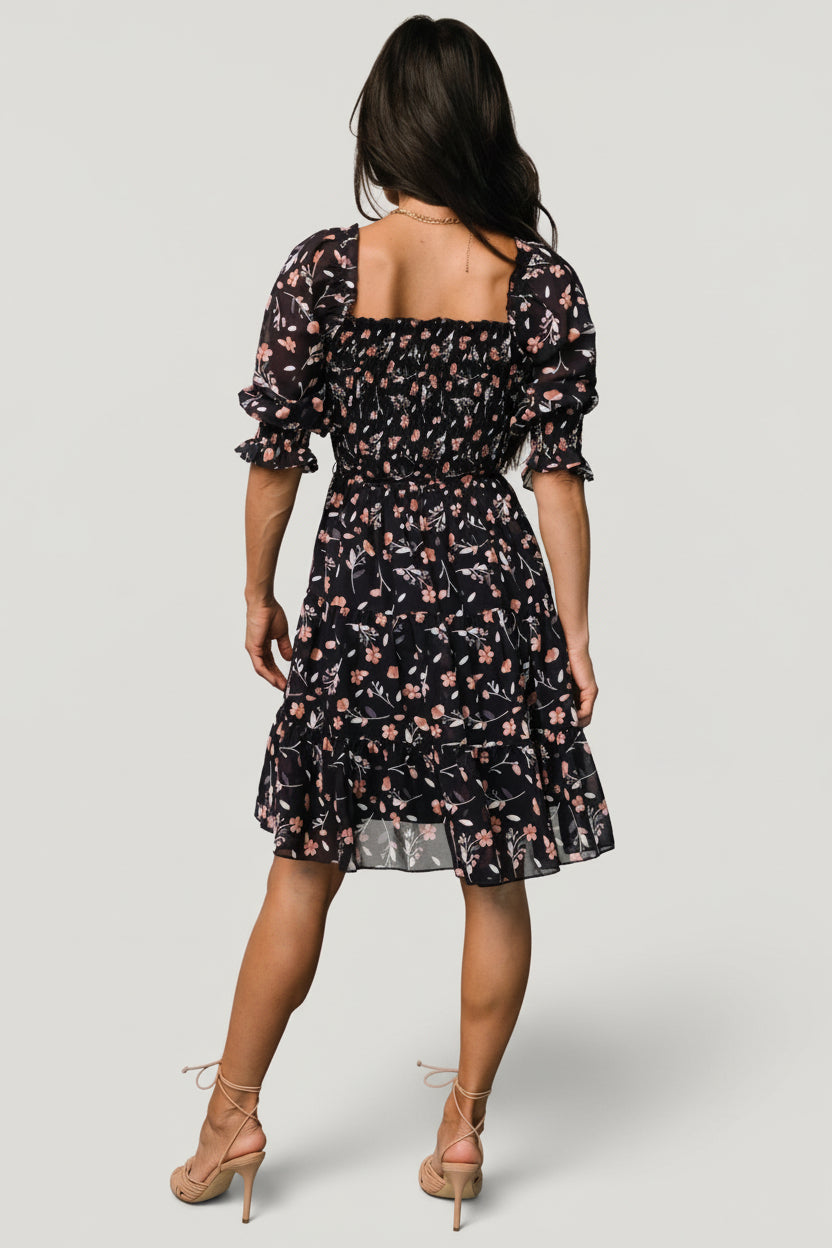Detail image of semi-sheer three-quarter sleeve with smocked ruffle cuff and detachable waist tie with tassels on navy floral fabric.