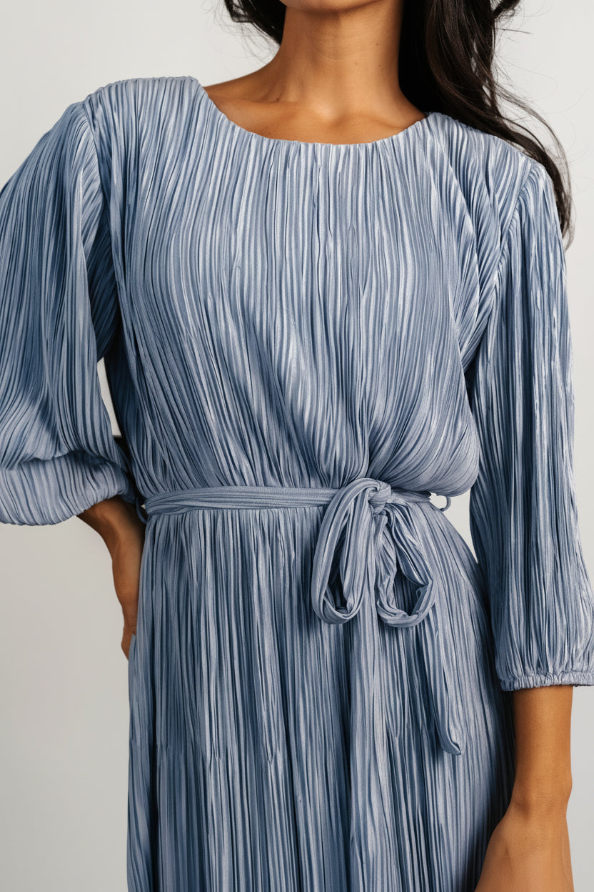 Detail shot of the Bethany Pleated Midi Dress waist showing the natural elastic waistline and adjustable self-tie sash in dusty blue.