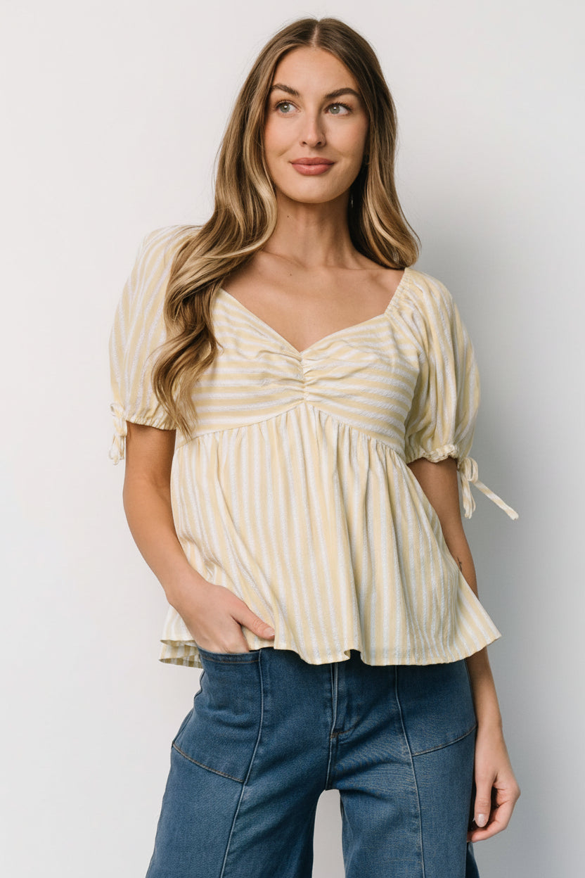 Front view of Betsy Peplum Top in pastel yellow and white stripes, showing peplum hem and gathered bust details.