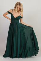 Front full-length view of Bianca Lace Maxi Dress in emerald, gathered lace bodice, flowing skirt and left-side slit for movement.