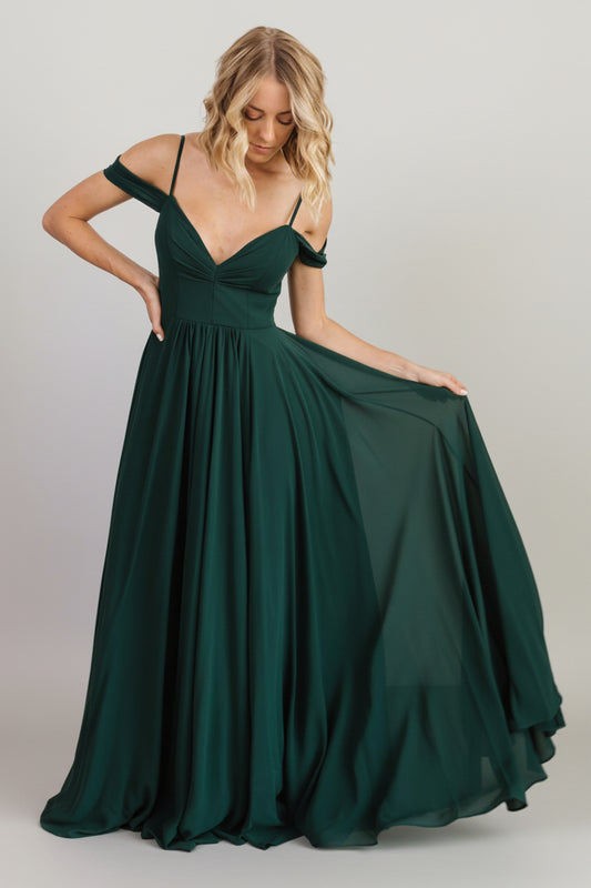 Front full-length view of Bianca Lace Maxi Dress in emerald, gathered lace bodice, flowing skirt and left-side slit for movement.