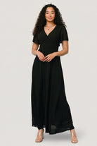 Close-up of the Birdie Maxi Dress bodice in black, highlighting V-neckline, smocked waist detail, and lightweight chiffon texture.