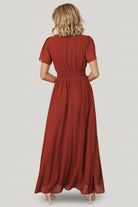 Close-up of the dress bodice in cinnamon showing the V-neck detail, smocked waist band, and delicate flutter sleeve edge.