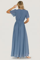 Close-up of the smocked waist and V-neckline on the Birdie Maxi Dress in Whisper Blue showing fabric texture and seam detail.