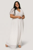 Three-quarter view of the Birdie white chiffon maxi dress highlighting smocked waist, soft pleating and flowing chiffon skirt movement.