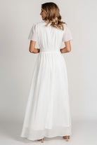 Full-length shot of model walking in the Birdie dress, illustrating skirt movement, flutter sleeves and ankle-grazing maxi length.