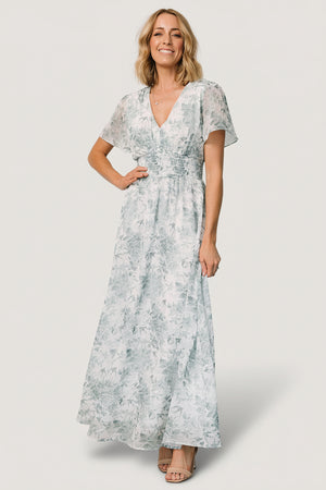 Front view of Birdie Maxi Dress in off-white with sage-green floral print; chiffon fabric, V-neck, short flutter sleeves, smocked waist.