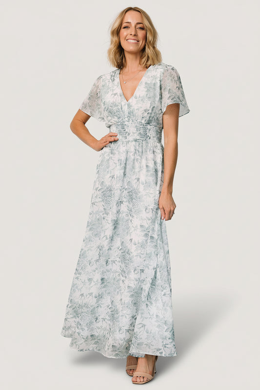 Front view of Birdie Maxi Dress in off-white with sage-green floral print; chiffon fabric, V-neck, short flutter sleeves, smocked waist.