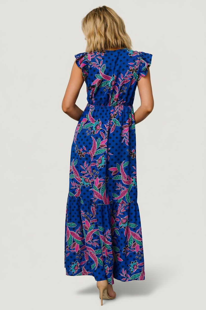 Lifestyle shot of dress in motion at sunset, showing multi-pattern indigo print, tiered hem, and versatile styling.