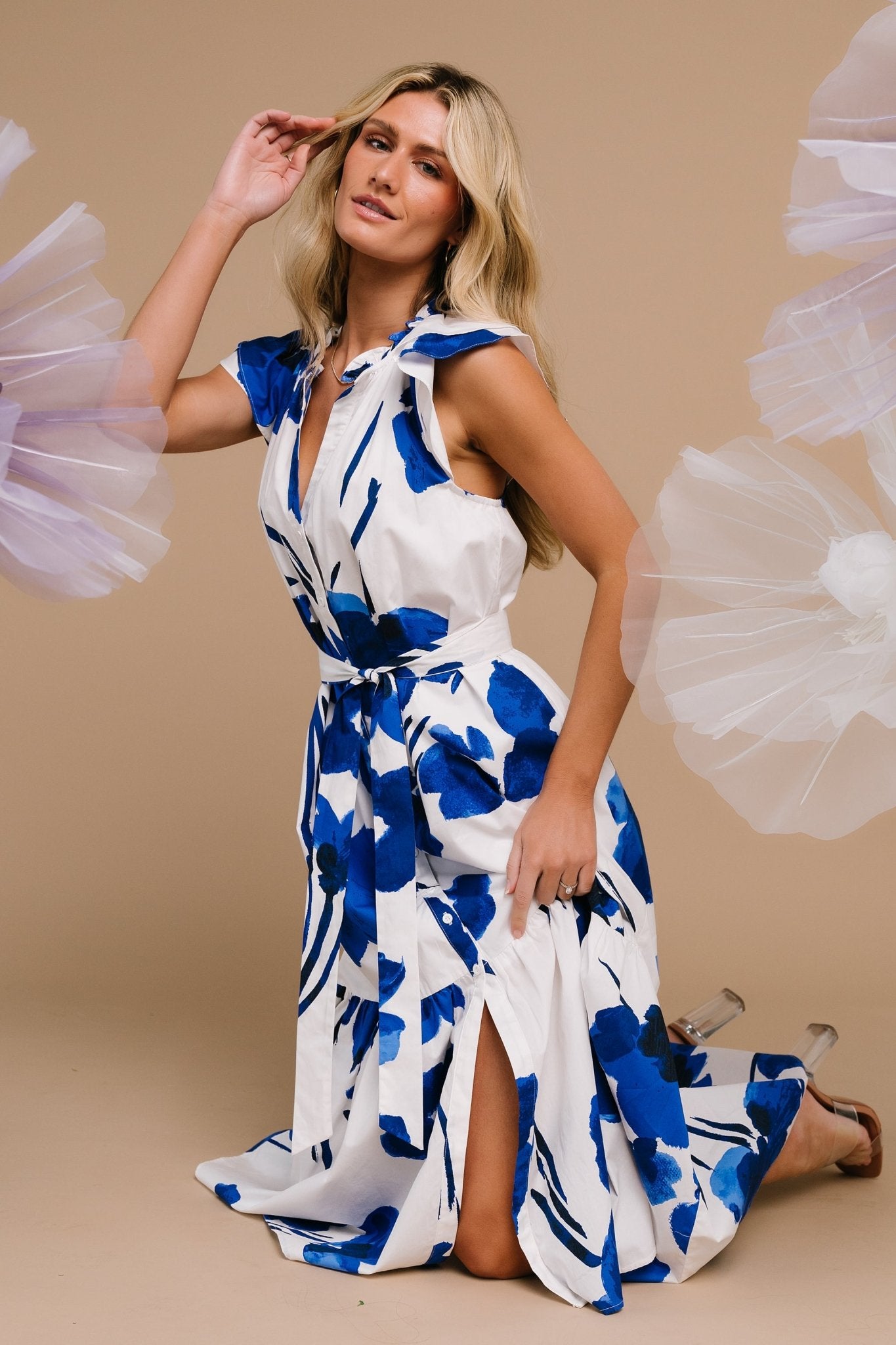 Model walking in the midi dress to show movement of the tiered skirt and flutter sleeves in the white and cobalt print.