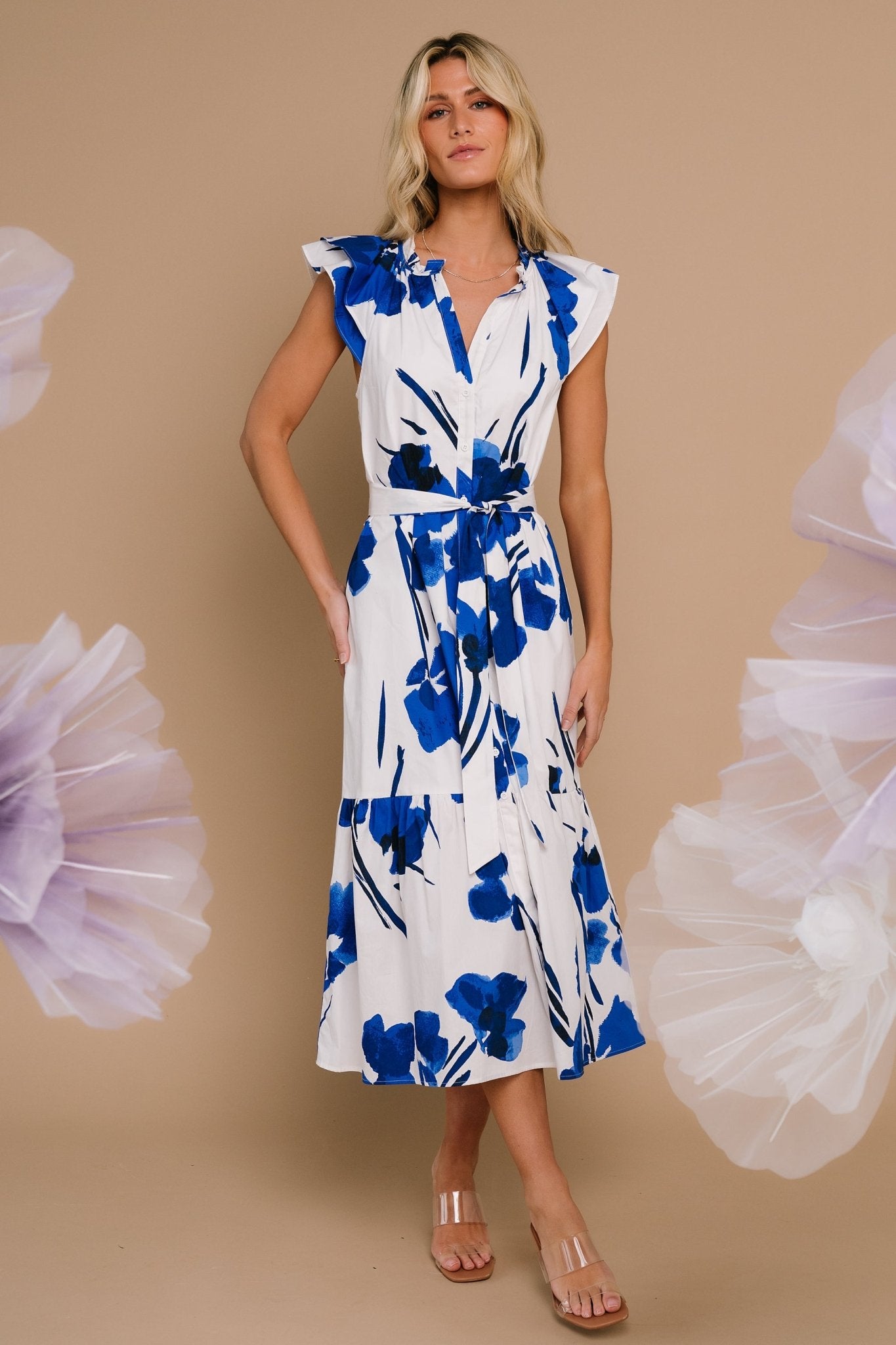 Three-quarter view showing the single-tiered midi skirt and removable waist tie on a model wearing the white and cobalt printed dress.