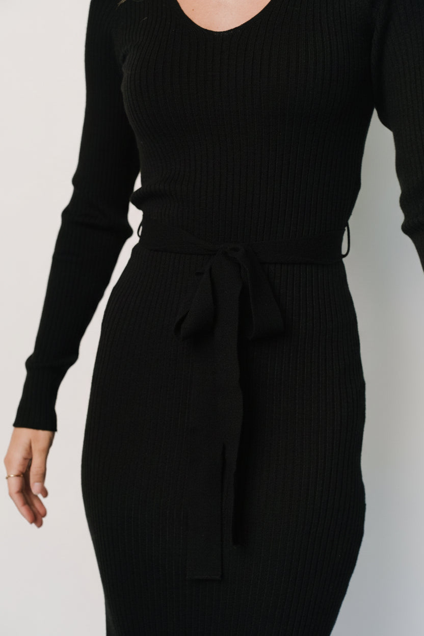 Detail photo of Blayne dress fabric and silhouette highlighting ribbed knit texture, neckline, and unfinished hem on the sleeve and skirt.